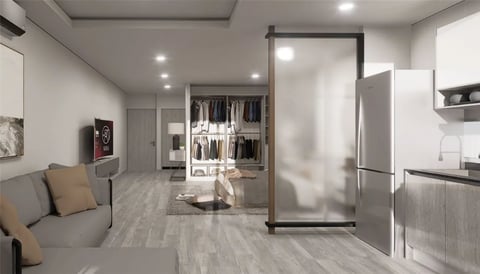 Interior de studio con sala, cocina integral, clóset con puertas de vidrio y electrodomésticos de acero inoxidable