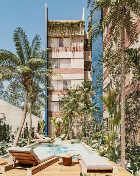 Tropical courtyard with swimming pool, wooden loungers, palm trees, and pink brick building with ivy-covered walls