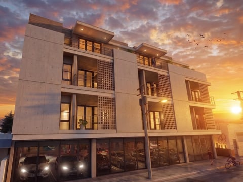 Modern apartment building with illuminated windows at golden sunset, featuring geometric lattice panels and ground-floor retail space