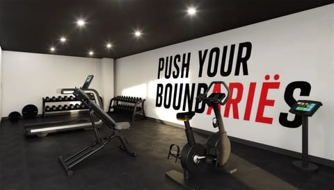 Gimnasio boutique con equipo de ejercicio y muro motivacional