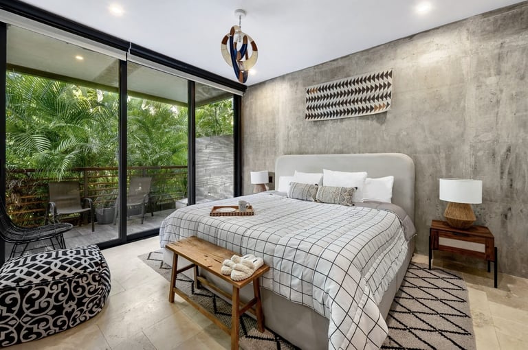 Modern bedroom with concrete wall and glass doors to garden