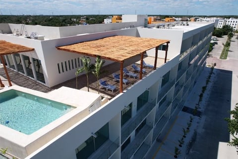 Rooftop terrace with swimming pool, wooden pergola, and city skyline view from modern white residential building