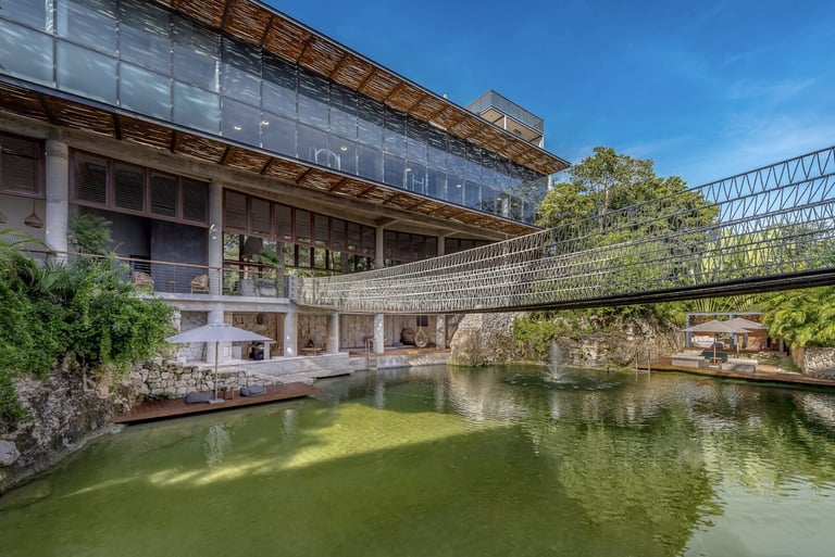 Modern building with glass facade overlooking green canal