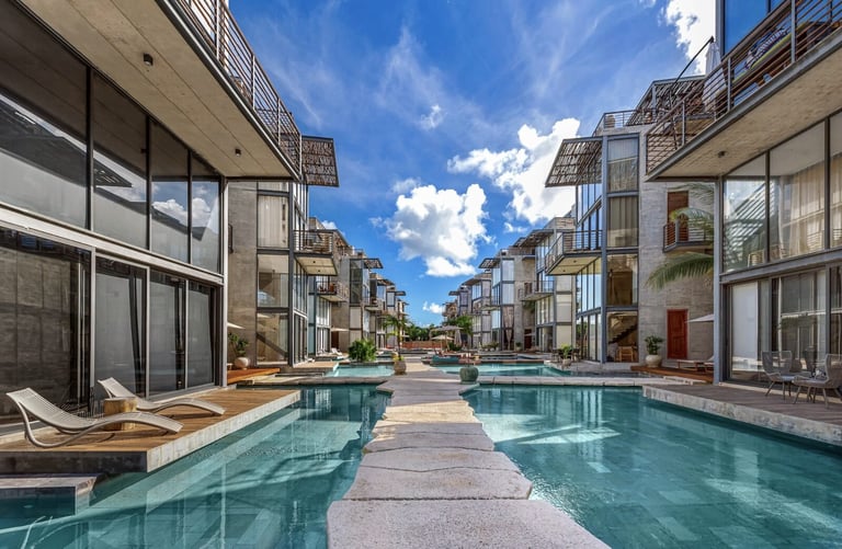 Luxury buildings flanking pool with lounge chairs