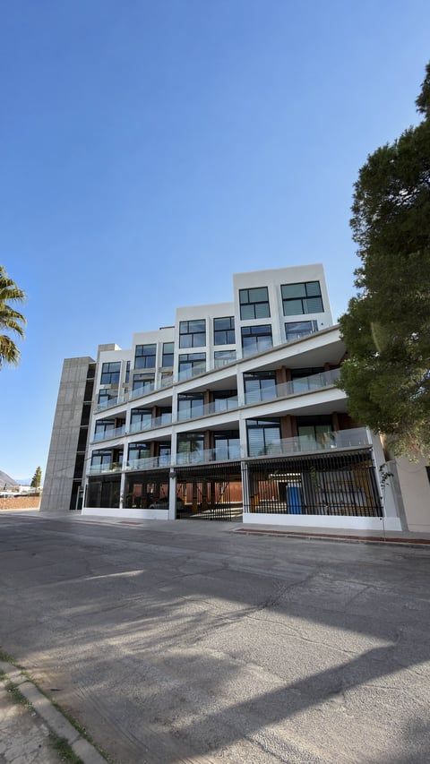 Fachada del edificio residencial Torre Alteza con balcones horizontales bajo cielo despejado