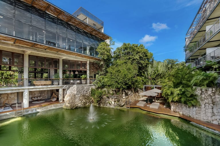 Modern glass building with green pond and lush vegetation