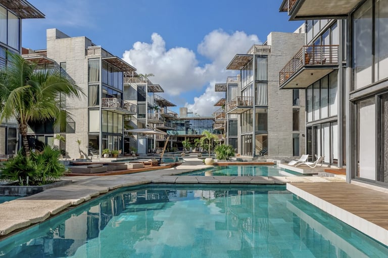 Residential complex with turquoise pool and tropical landscaping