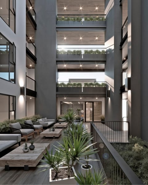 Modern courtyard with tiered balconies, seating areas, potted plants, and recessed lighting overlooking central garden